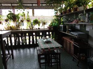 古晉的住宿－Marco Polo Guest House，配有桌椅和植物的房间