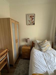 a bedroom with a bed and a table with a lamp at Comfortable Single Room Wembley Park/Stadium in London