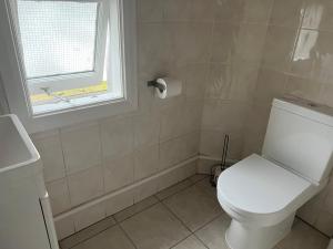 a bathroom with a white toilet and a window at Comfortable Single Room Wembley Park/Stadium in London