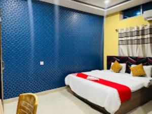 1 dormitorio con 1 cama con pared azul en Hotel Royal Palace Bongara, en Kāhārpāra