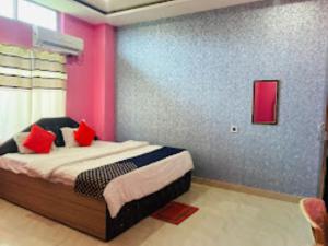 1 dormitorio con 1 cama con almohadas rojas en Hotel Royal Palace Bongara, en Kāhārpāra
