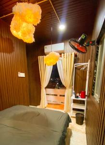 a bedroom with a bed with yellow curtains at SKY Homestay in Ấp Ðại Tài (2)