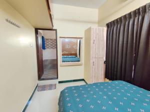 a bedroom with a blue bed and a mirror at luxury home in Vadavalli in Coimbatore