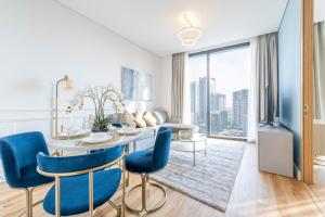 a living room with a table and blue chairs at Address Beach Residences in Dubai