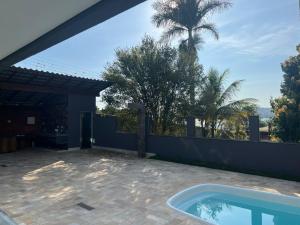 une terrasse avec une piscine et un palmier dans l'établissement RHsolart, à Lagoa Santa