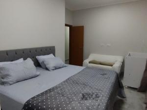 1 dormitorio con 1 cama grande y 1 silla en RHsolart en Lagoa Santa