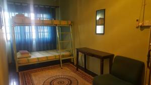 um quarto com 2 beliches e uma cadeira em Marco Polo Guest House em Kuching