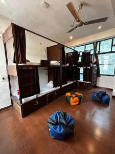 Cette chambre dispose de 3 lits superposés avec des sacs bleus au sol. dans l'établissement Sonu Guesthouse & Hostel, à Rishikesh