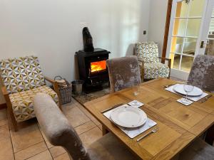 sala de estar con mesa de madera y estufa de leña en Luxury Home In Mourne Mountains, en Mayobridge