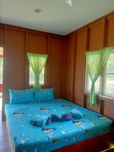 a bedroom with a blue bed with two windows at Lungcha Homestay in Sam Roi Yot