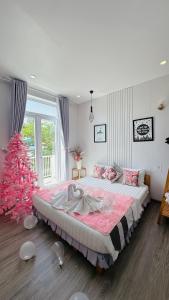 a bedroom with a large bed and a christmas tree at Sele House in Hà Tiên