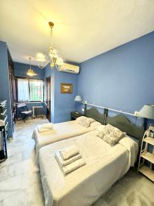 a bedroom with two beds and a blue wall at Villa Rural junto a la playa - SUN & RELAX in Marbella