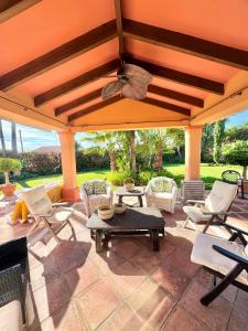 a patio with chairs and tables and a ceiling at Villa Rural junto a la playa - SUN & RELAX in Marbella