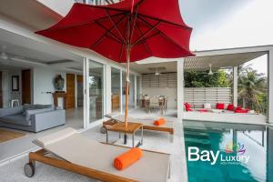 a house with a pool and a red umbrella at Luxury Asian Flair Villa in Ko Phangan