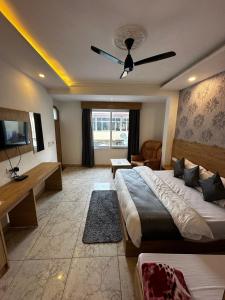 1 dormitorio con 1 cama grande y ventilador de techo en Sonu Guesthouse & Hostel en Rishīkesh