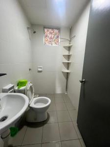 a bathroom with a toilet and a sink and a window at Putrajaya Homestay (Zurinn 2) in Putrajaya