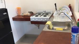 a kitchen with a stove and a sink at Bungalows en Los Barriles in Los Barriles