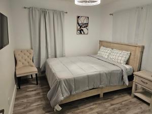 um quarto com uma cama e uma cadeira em Sunny Goldie em Lauderdale Lakes