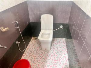 łazienka z toaletą w wyłożonej kafelkami łazience w obiekcie OYO Decent Inn w mieście Imphal