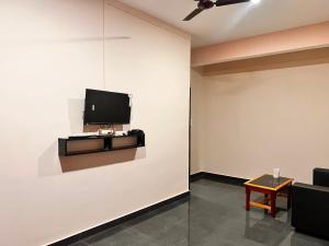 uma sala de estar com uma televisão na parede em OYO Decent Inn em Imphal