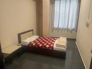 um pequeno quarto com uma cama e uma janela em OYO Decent Inn em Imphal