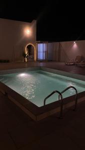 a large swimming pool at night with at The sunset farm in á¸¨aÅŸat al BidÄ«yah