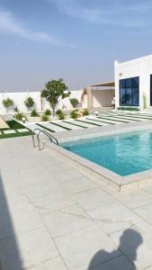 a swimming pool in front of a building at The sunset farm in á¸¨aÅŸat al BidÄ«yah