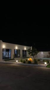 a building with lights in front of it at night at The sunset farm in á¸¨aÅŸat al BidÄ«yah