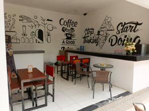 ein Restaurant mit Tischen und Stühlen und Graffiti an der Wand in der Unterkunft NK Villa Syariah And Cafe Prigen in Pasuruan