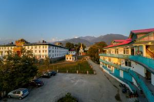 een uitzicht op een stad met auto's geparkeerd op een parkeerplaats bij Chokling ArtHouse - The Treasure of Himalayas in Bir