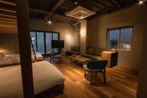 Kita-rokujōにあるGreen Room Hotelのベッド、ソファ、テーブルが備わるホテルルームです。
