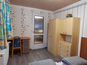 a bedroom with a desk and a dresser and a door at Sasvár Vendégház in Parádsasvár