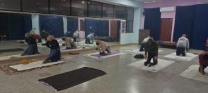 un grupo de personas haciendo yoga en una habitación en Yog Bhawan, en Greater Noida