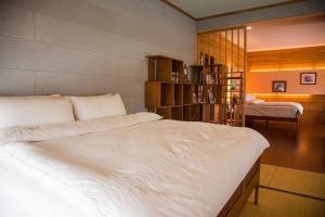 a bedroom with a large white bed in a room at 快樂鼠樓中樓4-6人房 in Taitung City