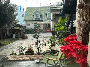 a patio with red flowers and a green chair at 快樂鼠樓中樓4-6人房 in Taitung City