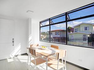 a dining room with a table and chairs and a large window at Apartamento Bellavista en San Jose in San José