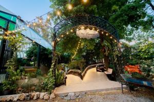 a garden with an arch with lights and a walkway at de lamont in Ban Sathani Bandai Ma
