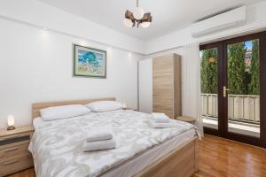 Un dormitorio blanco con una cama grande y una ventana en Family House Rose with Pool - Happy Rentals, en Pinezici