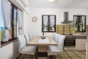 cocina con mesa de madera y sillas blancas en Family House Rose with Pool - Happy Rentals, en Pinezici
