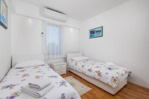 1 dormitorio con 2 camas y ventana en Family House Rose with Pool - Happy Rentals, en Pinezici