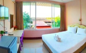 ein Schlafzimmer mit einem großen Bett und einem großen Fenster in der Unterkunft โรงเเรมคิงส์พาเลซ King's Palace HOTEL in Seka