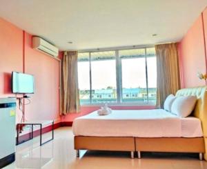 1 dormitorio con 1 cama grande y paredes de color rosa en โรงเเรมคิงส์พาเลซ King's Palace HOTEL en Seka