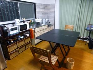 a dining room with a table and a microwave at こや・かやき in Yufu