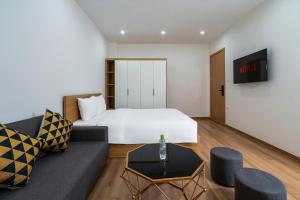 a hotel room with a bed and a couch at Casa Feliz Serviced Apartment in Hanoi