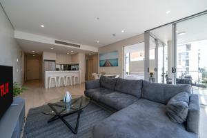 a living room with a gray couch and a table at Spectacular City & Harbour Views: Bondi Junction in Sydney