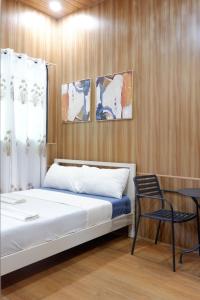 a bedroom with a bed and a chair in it at Malaybalay Air’bnb Travellers Inn in Malaybalay