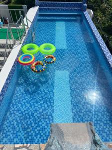 a swimming pool with two inflatable rings in the water at Dante's Hideaway Guest House in Boracay