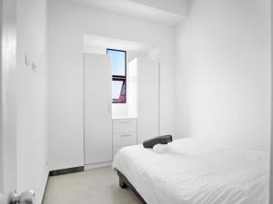a white bedroom with a bed and a mirror at Casa Bellavista Suites in San José