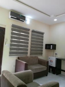 a living room with a couch and a tv at F&B Service Apartment in Abeokuta