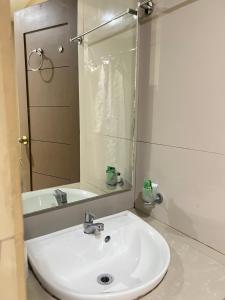 y baño con lavabo blanco y espejo. en Dante's Hideaway Guest House en Boracay
